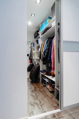 Dolabında beyaz elbiseler ve ayakkabıların asılı olduğu modern dolap, iç mekan modern apartman.