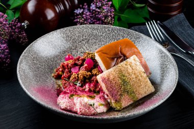 Tabakta çiğ et tartartarı, siyah ahşap masa arkası, şefin güzel servisinden sığır eti tartar.