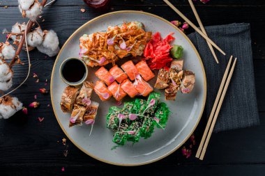 Suşi ahşap masada yuvarlak, büyük set suşi tabaktaki üst görüntüyü yuvarlar.