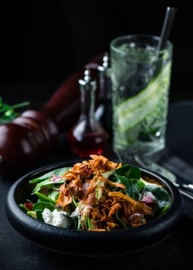 Ispanakla servis edilen gurme salatası, siyah arka planda marul. Lezzetli salata. Sağlıklı yiyecekler. Pahalı bir restoranda peynirli taze arkaplan salatası kopyala