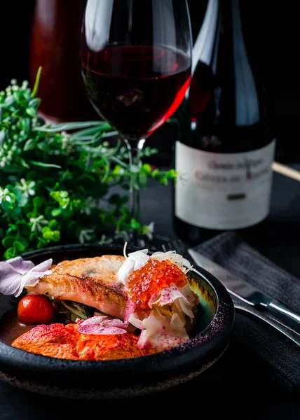 Izgara beyaz balık ve sebzeli akşam yemeği tabağı ve kırmızı havyar, restoranda pişmiş beyaz balık.