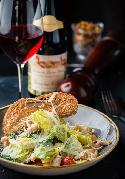 Tavuklu Sezar salatası ve ahşap masa, pahalı bir restoranda Sezar salatası.