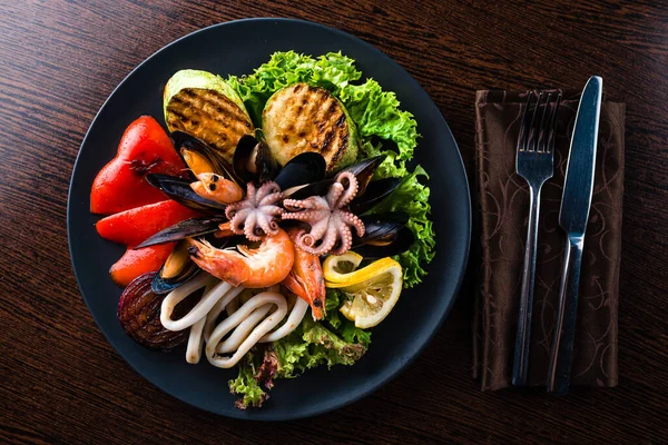 Seafood platter, plate with seafood and grilled vegetables top view, flat lay
