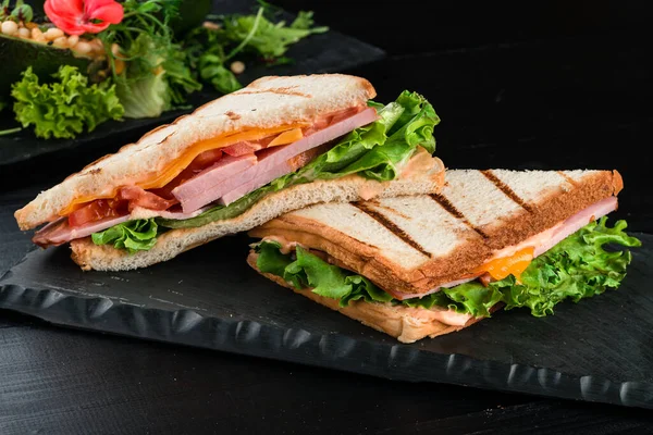 Grilled toast with ham cheese tomato and lettuce, grilled sandwich with ham and salad
