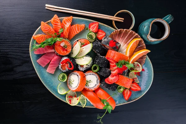 Sushi Set nigiri, rolls and sashimi served, large plate with sashimi and sushi, set of Japanese food top view, flat lay