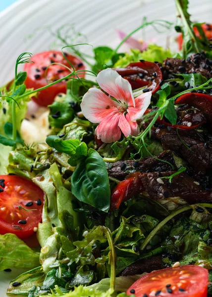 Colorful summer salad with edible flowers. salad decorated with flowers close up
