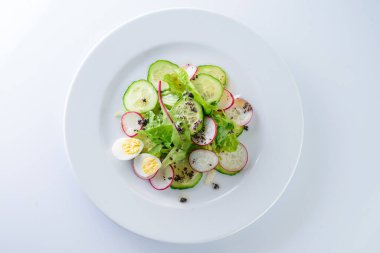 Taze sebze salatası kaseye, beyaz arka plan manzarası, düz salata ve taze turplar.