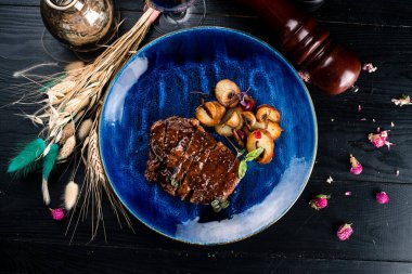 Parça parça kesilmiş ızgara Striploin Angus bifteği. Dilimlenmiş biftek Top View Mavi bir plaka üzerinde yatıyordu