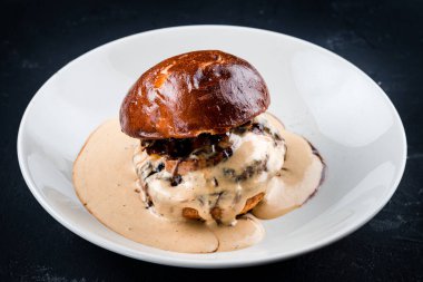 Pastırmalı, peynirli ve soslu taze sığır etli burger.