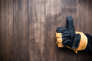 İnşaat eldivenindeki el hareketi ahşap ahşap kaplama arka plan görüntüsü, boşluk kopyala