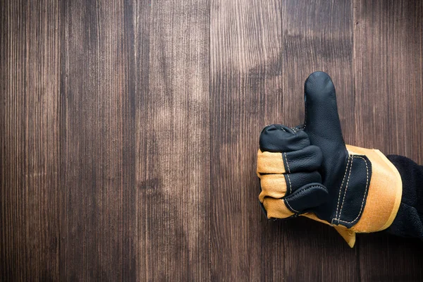 İnşaat eldivenindeki el hareketi ahşap ahşap kaplama arka plan görüntüsü, boşluk kopyala