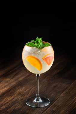 Portakal dilimleri ve nane şekeri ile süslenmiş beyaz şarap kadehi. Klasik beyaz şarap sangria.