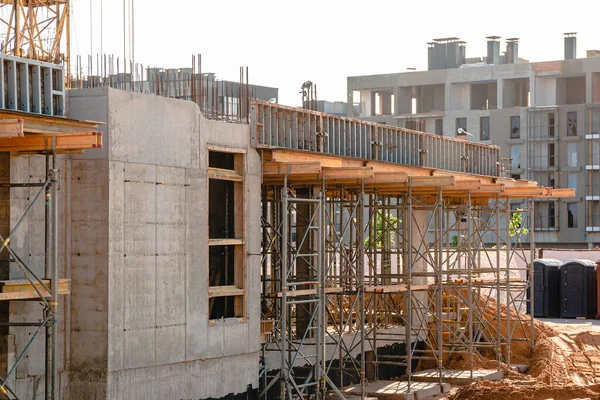 Modern construction site with scaffolding, housing construction frame concrete