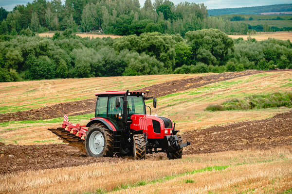 Farmer in tractor preparing land, farmer on a tractor plowing the land. Agricultural machinery in field