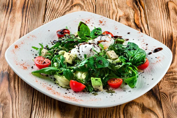 Healthy summer lentil salad with caramelized pear, arugula and poached egg soft on top, fresh salad with poached egg