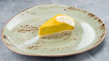 Tabakta limonlu cheesecake yakın çekim alanı, lezzetli ev yapımı limonlu cheesecake parçaları ve dilimler.
