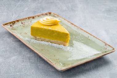 Tabakta limonlu cheesecake yakın çekim alanı, lezzetli ev yapımı limonlu cheesecake parçaları ve dilimler.