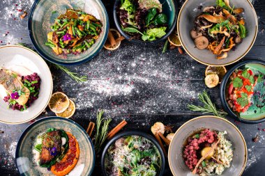 Akdeniz Tabakları Sınırı masada. Uzayı karanlık ahşap yüzeyin üzerine kopyalayın. Ahşap masa boş fotokopi alanı ortada, tabaklar üstte.