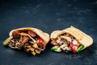 Tahta bir arka planda kıyma ve sebzeli dürüm.