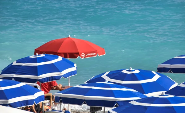 Parasol Garde Soleil Rouge Planche Plage Parmi Les Parasols Bleus — Photo