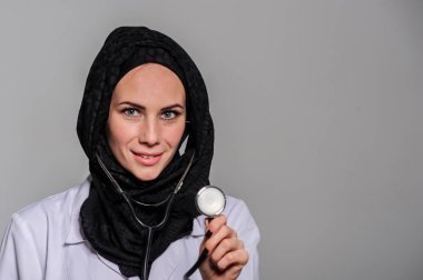 Samimi, gülümseyen emin Arap kadın doktor, sağlık uzmanı beyaz arka plan üzerinde izole closeup portresi.