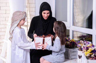 Arapça anne onun erkek ve kız için hediye vermek. Müslüman aile.