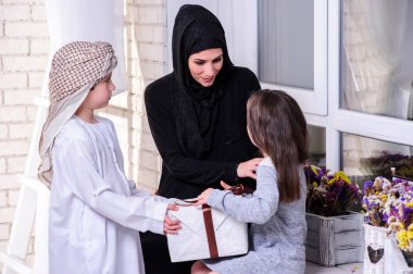 Arapça anne onun erkek ve kız için hediye vermek. Müslüman aile.