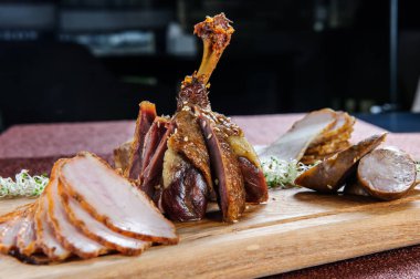 Pekin ördeği ve satır kesme tahtası üzerinde kahverengi ahşap zemin üzerinde dilimlenmiş.