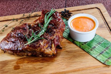 Ahşap masa üzerinde ahşap kesme plaka üzerinde ızgara domuz eti biftek. Avrupa gıda.