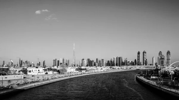 Pôr-do-sol colorido sobre os arranha-céus do Dubai Downtown e a recém-construída ponte Tolerance vista do canal de água do Dubai . — Fotografia de Stock