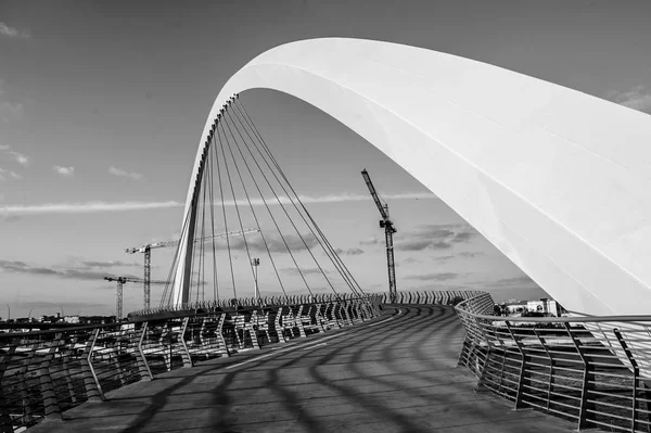 Black e wite pôr do sol sobre Downtown Dubai arranha-céus e a recém construída ponte de tolerância como se fosse visto do canal de água de Dubai. — Fotografia de Stock