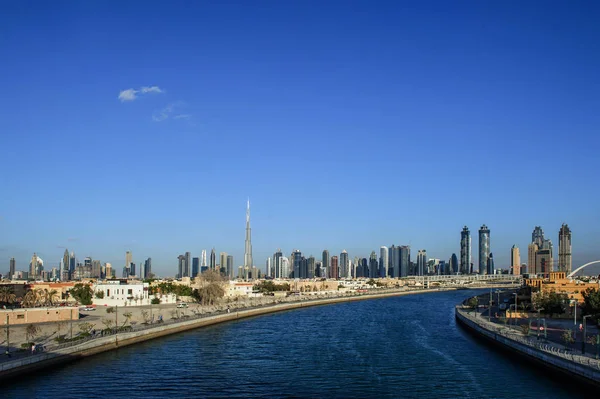 Colorful sunset over Dubai Downtown skyscrapers and the newly built Tolerance bridge as viewed from the Dubai water canal. — Stock Photo, Image