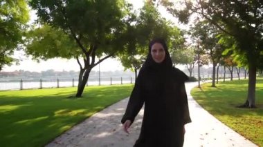 Dubai,Bae'deki Barsha parkında mornig yürüyüşü keyfi nde bulunan gülümseyen Arap kadın.