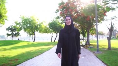 Dubai,Bae'deki Barsha parkında mornig yürüyüşü keyfi nde bulunan gülümseyen Arap kadın.