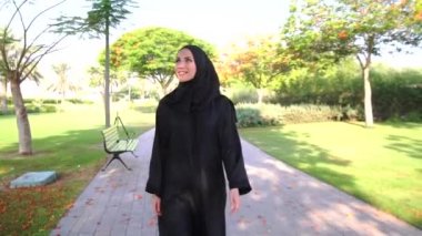 Dubai,Bae'deki Barsha parkında mornig yürüyüşü keyfi nde bulunan gülümseyen Arap kadın.