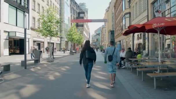 Leipzig, Tyskland - 1 maj 2018. Ungt par promenader längs bilfra gatan i centrum — Stockvideo