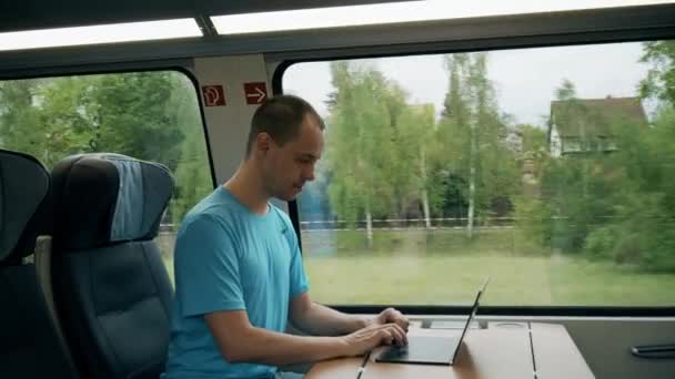 Hombre trabajando en su portátil moderno mientras viaja en tren — Vídeos de Stock