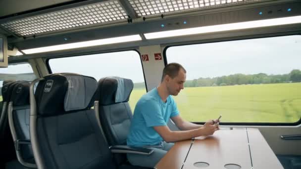 Человек, использующий свой мобильный телефон в поезде — стоковое видео