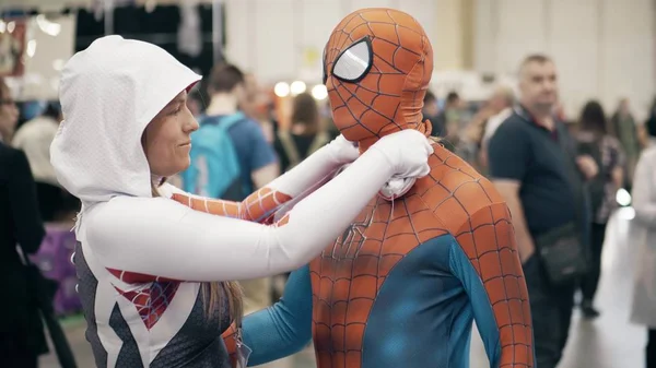 POZNAN, POLÓNIA - 19 de maio de 2018. Jovem mulher ajuda o homem a usar traje de cosplay Homem-Aranha — Fotografia de Stock