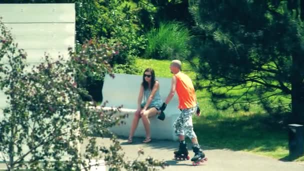 WARSAW, POLONIA - 31 DE MAYO DE 2018. Joven en camiseta naranja patinando en el parque de la ciudad — Vídeos de Stock