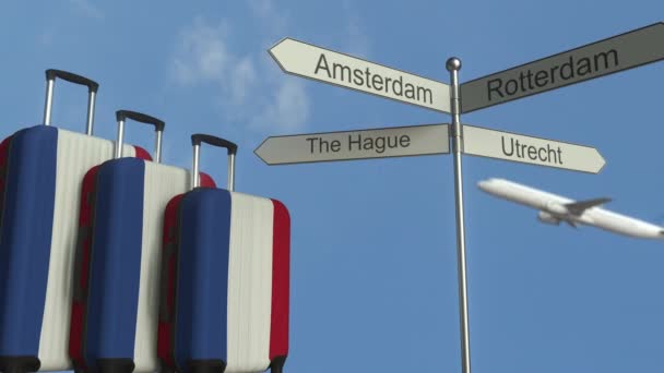 Bagages de voyage avec drapeau des Pays-Bas, avion et panneau de signalisation de la ville. Tourisme néerlandais animation conceptuelle — Video