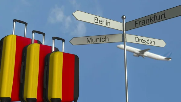 Bagagem de viagem com bandeira da Alemanha, avião e poste de sinalização da cidade. Alemão turismo conceitual 3D renderização — Fotografia de Stock