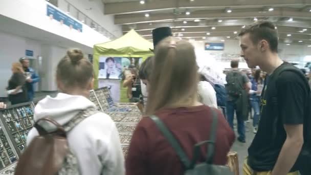POZNAN, POLONIA - 19 DE MAYO DE 2018. Pyrkon visitantes de la convención en el puesto de mercancías — Vídeos de Stock