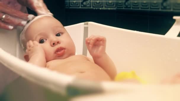 Mother washing baby girls hair with shampoo — Stock Video