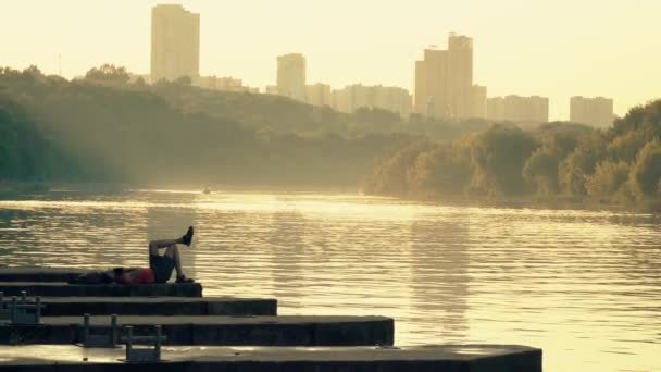 Homme méconnaissable se reposant sur la jetée dans le parc de la ville — Video