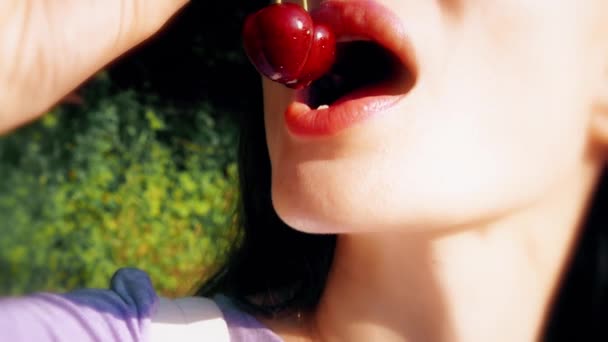 Hermosa mujer joven comiendo cerezas dulces tiro de cerca — Vídeos de Stock
