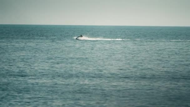 Personas distantes montando moto acuática en el mar, tiro en cámara lenta — Vídeo de stock