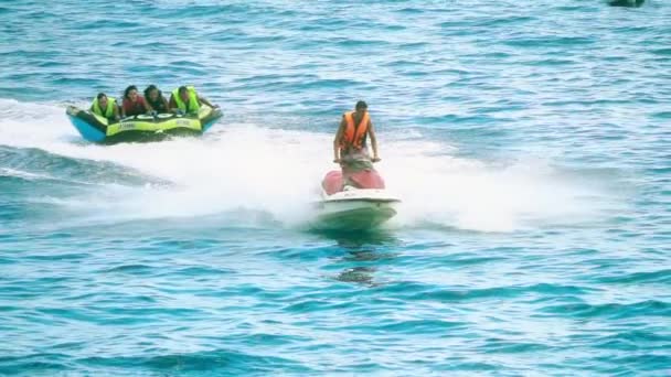 BUDVA, MONTENEGRO - 26 LUGLIO 2018. Le persone si divertono a cavalcare gommone trainato da jet ski, tiro al rallentatore — Video Stock