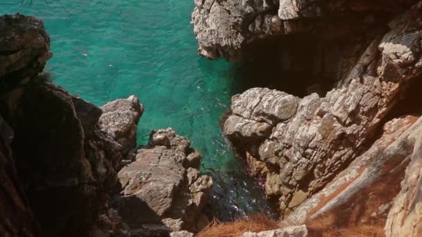 Lanzamiento en cámara lenta de ondas marinas cerca de las rocas en un día soleado — Vídeo de stock