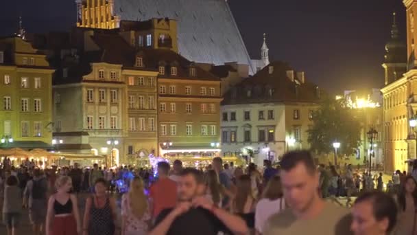 ВАРШАВА, ПОЛЬША - 4 августа 2018 года. Туристы ходят по площади в старом городе вечером — стоковое видео